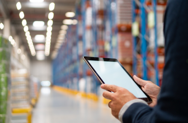 Person kontrolliert Warenbestände im Lager mit einem Tablet
